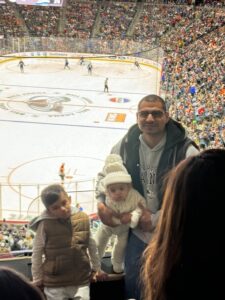 A man and his children at the Colorado Avalanche game enjoyed by River Deep Foundation participants