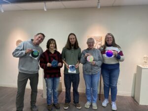 A group proudly holding their star embroidery after a lesson at the Cottonwood Arts Center 